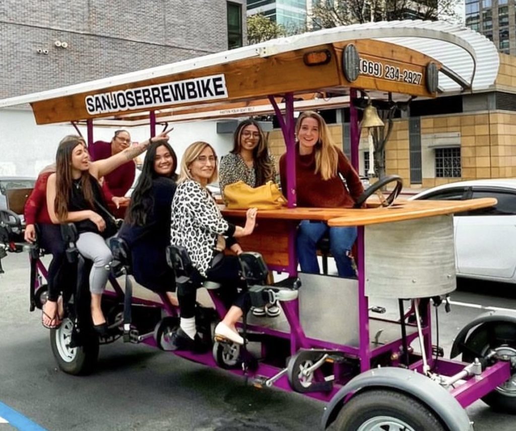 Smiling group of people team building with San Jose Brew Bike